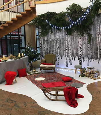 déco de Noël ambiance scandinave avec forêt de bouleaux, bûches, moquette blanche, luge en bois et accessoires