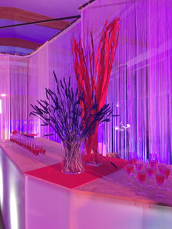 bouquet de fleurs séchées posée sur un bar en polycarbonate et entourés de verres d'apéritif